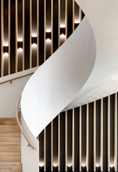 a spiral staircase in a modern building with wooden slats on the wall and floor