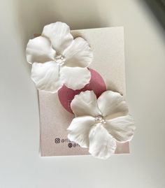 three white flowers sitting on top of a piece of paper