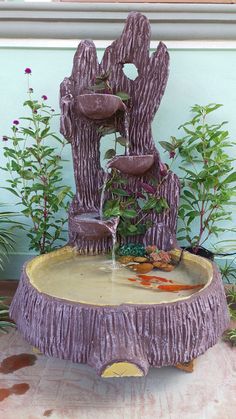 a purple fountain in the middle of a garden