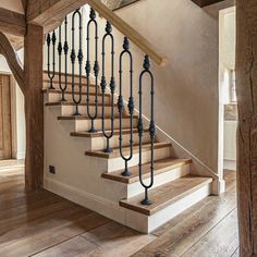 a staircase with iron railings and wood flooring