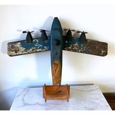 an old airplane is hanging on the wall with four birds perched on it's wings