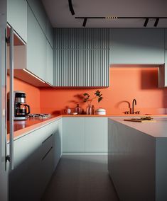 a kitchen with an orange wall and white counter tops, along with appliances on the counters