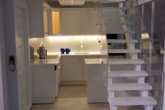 there is a kitchen and stairs in the room that leads up to the second floor