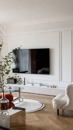 a living room filled with furniture and a flat screen tv mounted on the wall above a fireplace