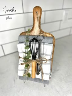 a kitchen utensil holder with a whisk and green leaves on it