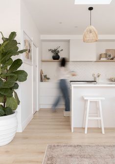 a blurry image of a person in a kitchen with an island and stools