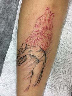 a woman's arm with a wolf tattoo on the left side of her leg