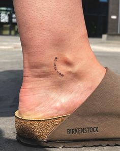 a person's foot with a small tattoo on it