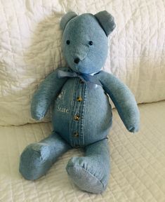 a blue teddy bear sitting on top of a bed