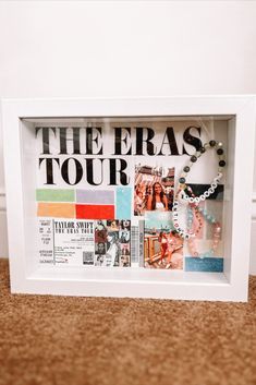 the eras tour is displayed in a white frame with beaded necklaces on it