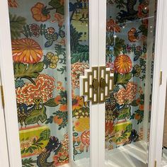 the glass doors are decorated with colorful wallpapers and gold handles on each side