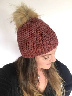 a woman wearing a red knitted hat with pompom