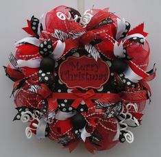 a red and black christmas wreath with zebra print, polka dots, and ribbon around it