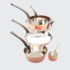 three pots and two pans are shown with spoons in the bottom right hand corner