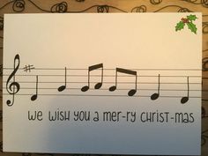 a christmas card with musical notes and holly berry on the top, which reads we wish you a merry christmas