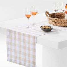 a table topped with wine glasses next to a bowl of food