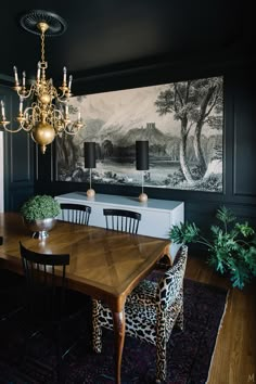 the dining room is decorated in black and white with leopard print chairs, an antique chandelier, and a painting on the wall