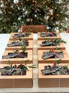 several boxes are wrapped in brown paper and tied with twine ribbons, sitting on a table next to a christmas tree