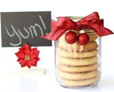 a glass jar filled with cookies next to a chalkboard and red poinsetti