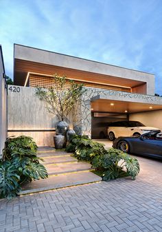 two cars parked in front of a modern house