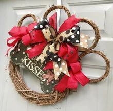 a wreath that has been decorated with red and black bows on the front door handle