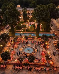 an aerial view of a courtyard with tables and umbrellas in the center at night