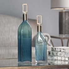 two blue vases sitting on top of a table in front of a couch and lamp