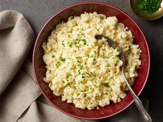 a red bowl filled with mashed potatoes on top of a table