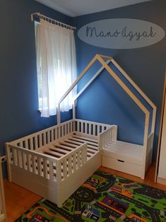 a child's room with blue walls and white bed frame in the shape of a house