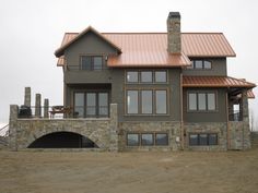 a large house with stone and copper roofing