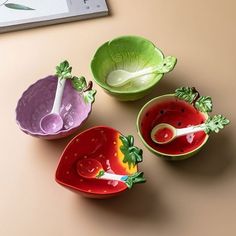 three bowls with spoons in them sitting on a table