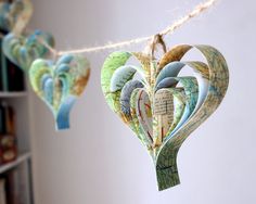 paper hearts are hanging from a string in the shape of a heart on a bookshelf