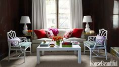 a living room filled with white furniture and red pillows