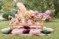 an outdoor party with balloons, cake and decorations