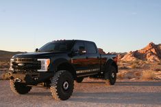 a large black truck parked in the desert