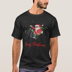 a man wearing a black shirt with santa clause on it's chest and riding a bike