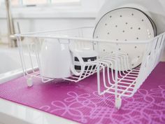 a dish rack with dishes in it sitting on a counter