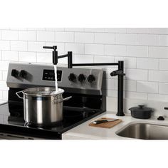 a stove top oven sitting next to a sink with a pot on the burner