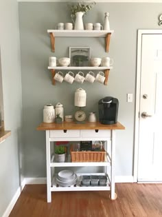 a kitchen island with coffee cups on it and other items sitting on the top shelf