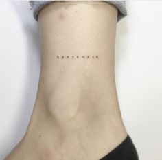 a woman's neck with the word september written on her left side ribcage