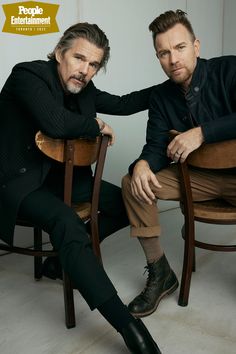 two men sitting on wooden chairs in front of a white wall with the caption people entertainment