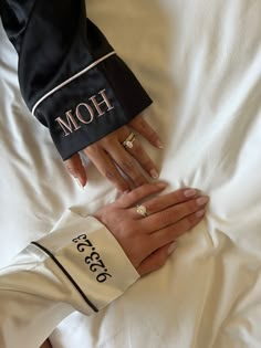 two people holding hands on top of a bed