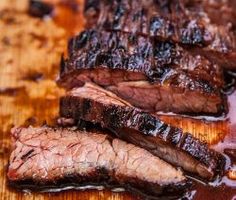 sliced steak on wooden cutting board with sauce