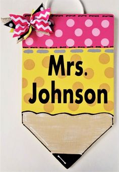 a hand painted sign with a pencil on it's side and the name mrs johnson