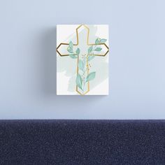 a cross with green leaves on it mounted on a wall