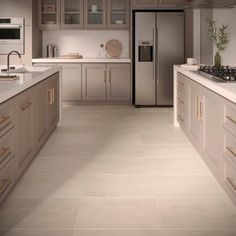 a kitchen with white counter tops and beige cupboards on both sides of the room