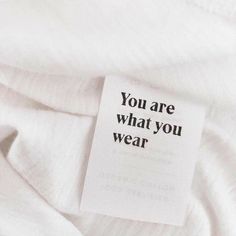 a white shirt with a tag that says you are what you wear on the label