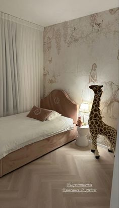 a giraffe standing in the corner of a bedroom next to a bed and lamp