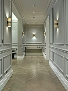 an empty room with white walls and wood flooring is shown in this image, there are two lights on either side of the wall