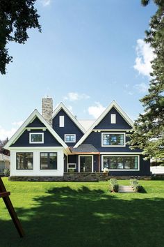 a large blue house with white trim and windows